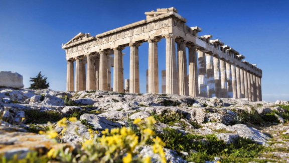 Parthenon auf der Akropolis in Athen mit felsigem Vordergrund und gelben Blumen