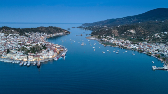 Luftaufnahme einer griechischen Küstenstadt mit Hafen, Booten und ruhiger Bucht