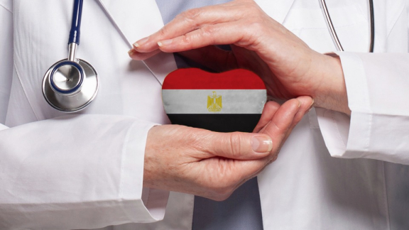 Gesundheitssystem in Ägypten: Ein Arzt hält ein Herz ein Herz in den Farben der ägyptischen Flagge schützend in den Händen