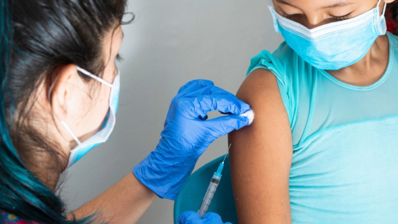 Eine kolumbianische Ärztin impft ein Kind - Gesundheitssystem in Kolumbien