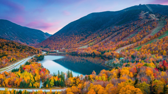 Landschaft in den USA mit See, Bergen und buntem Mischwald