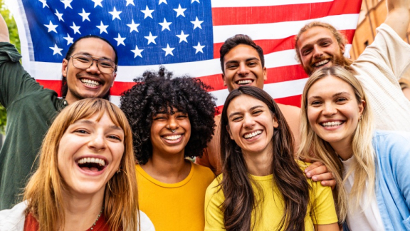 Menschen aus den USA mit einer Landesflagge lächeln in die Kamera