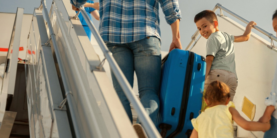 Family with children boarding an airplane – symbolic image for international moving