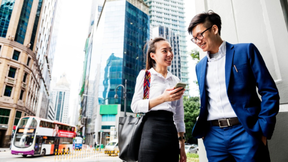 Eine Frau und ein Mann aus Singapur unterhalten sich auf der Straße über ihr Business