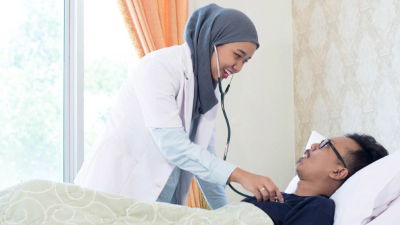 Eine malaysische Ärztin untersucht einen Patienten mit einem Stethoskop