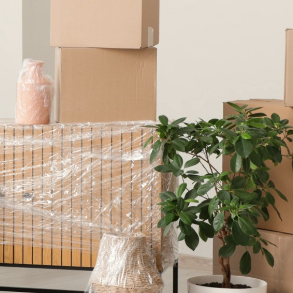 Ein Wohnraum mit verpackten Möbeln und gestapelten Umzugskartons. Symbolisiert den Relocation Service für Privatpersonen.