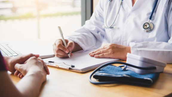 Ein Arzt aus Israel führt ein Gespräch mit einem Patienten und macht sich Notizen