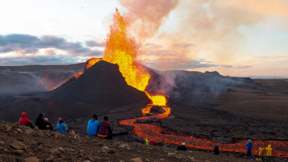 Vulkanausbruch in Island mit fließender Lava und Menschen in sicherer Entfernung