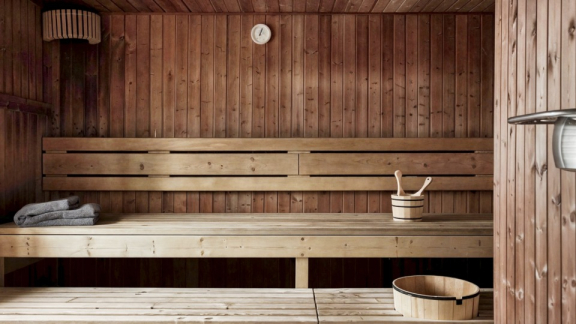Holzsauna in Finnland mit Saunabänken, Eimer und Handtüchern