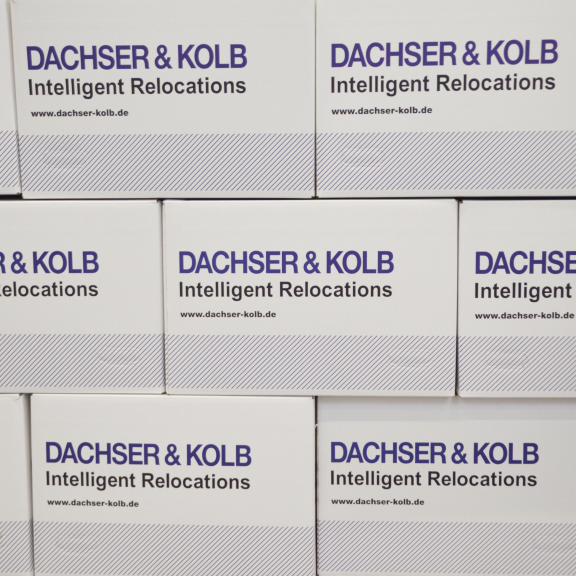 Umzugskartons von DACHSER & KOLB mit Slogan