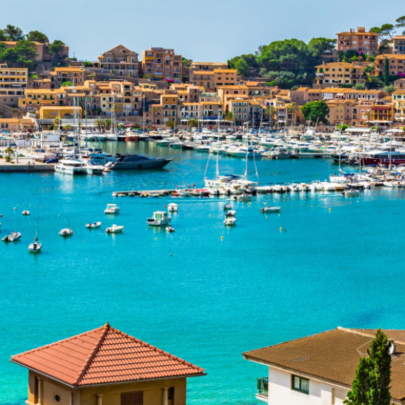Küstenstadt in Spanien mit Yachthafen, türkisblauer Bucht und Strand an einem sonnigen Tag