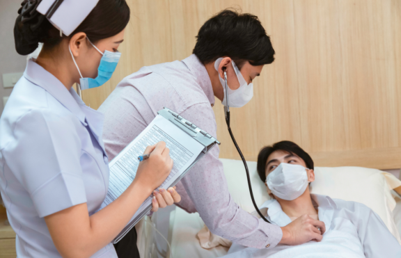 Arzt und Pflegekraft untersuchen einen Patienten im Krankenhaus