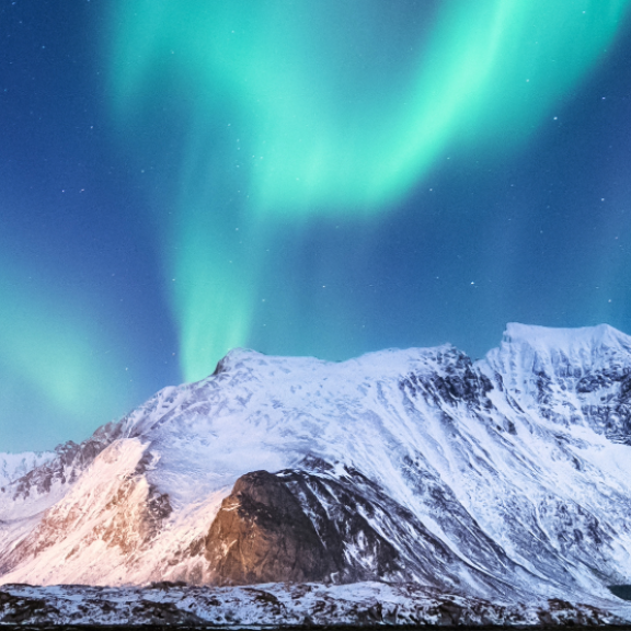 Nordlichter über schneebedeckten Bergen in Finnland bei klarem Nachthimmel
