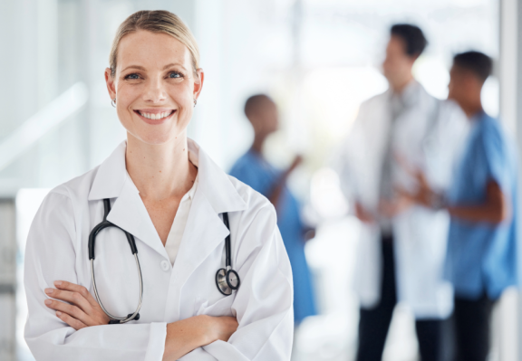 Ärztin in Klinik mit medizinischem Team im Hintergrund als Symbol für das Gesundheitssystem in Finnland