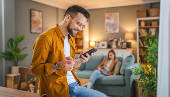 Mann zeigt Interesse an Wohnungsbewerbung per Smartphone nach der Besichtigung