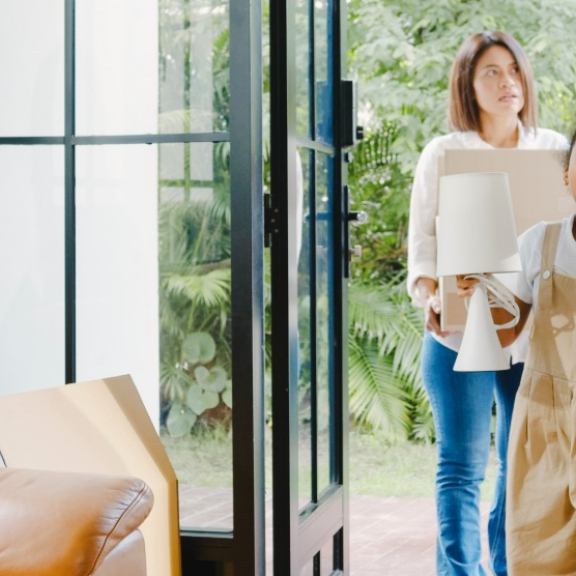 Familie trägt Umzugskartons ins neue Zuhause – Symbolbild für praktische Wohntipps