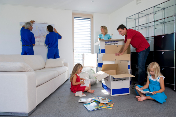Umzugsdienstleistungen in Aktion: Möbel werden montiert, Kartons ausgepackt und Kinder genießen Bücher im neuen Zuhause.