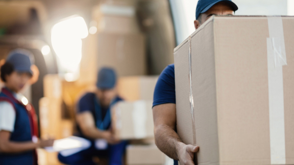 Umzugsdienstleistungen in Aktion: Möbel werden montiert, Kartons ausgepackt und Kinder genießen Bücher im neuen Zuhause.