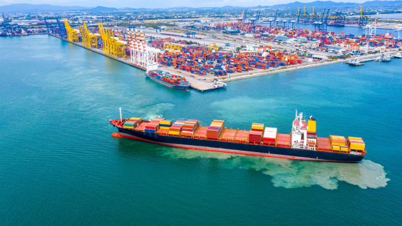 Containerschiff im Einfuhrhafen – POE (Port of Entry) mit bunten Containern und Hafenkränen im Hintergrund.