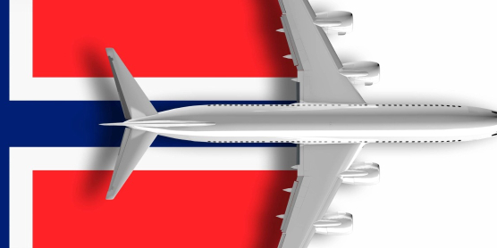 Flugzeug in Draufsicht über norwegischer Flagge als Symbolbild für Reisen nach Norwegen