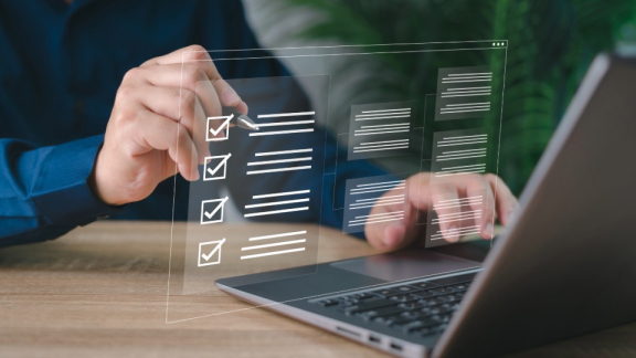 Person am Laptop nutzt digitale Checkliste – Vorbereitung auf Röntgenbeschau und Sicherheitskontrolle