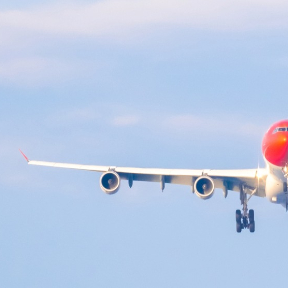 Airplane on approach against a blue sky, symbolic image for Thailand visa and entry