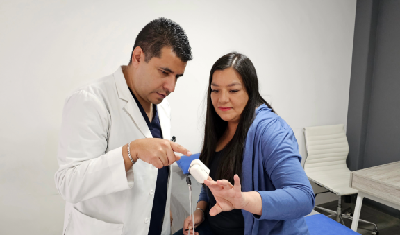 Ein Arzt misst mit einem Pulsoximeter die Vitalwerte einer Patientin