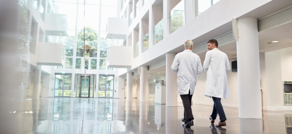 Zwei Ärzte laufen durch eine Eingangshalle einer Klinik in Thailand