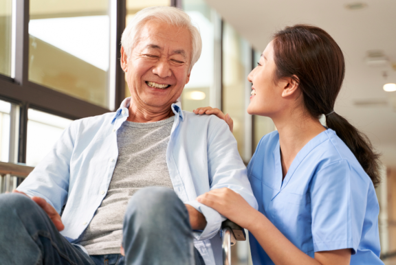 Eine Arzthelferin kümmert sich um einen älteren chinesischen Patienten