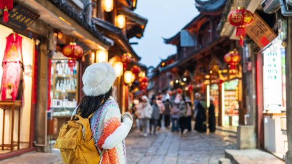 Eine Dame steht auf einer belebten Einkaufsstraße in China